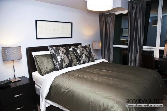 furnished suites toronto harbourfront bedroom with grey sheets and desk