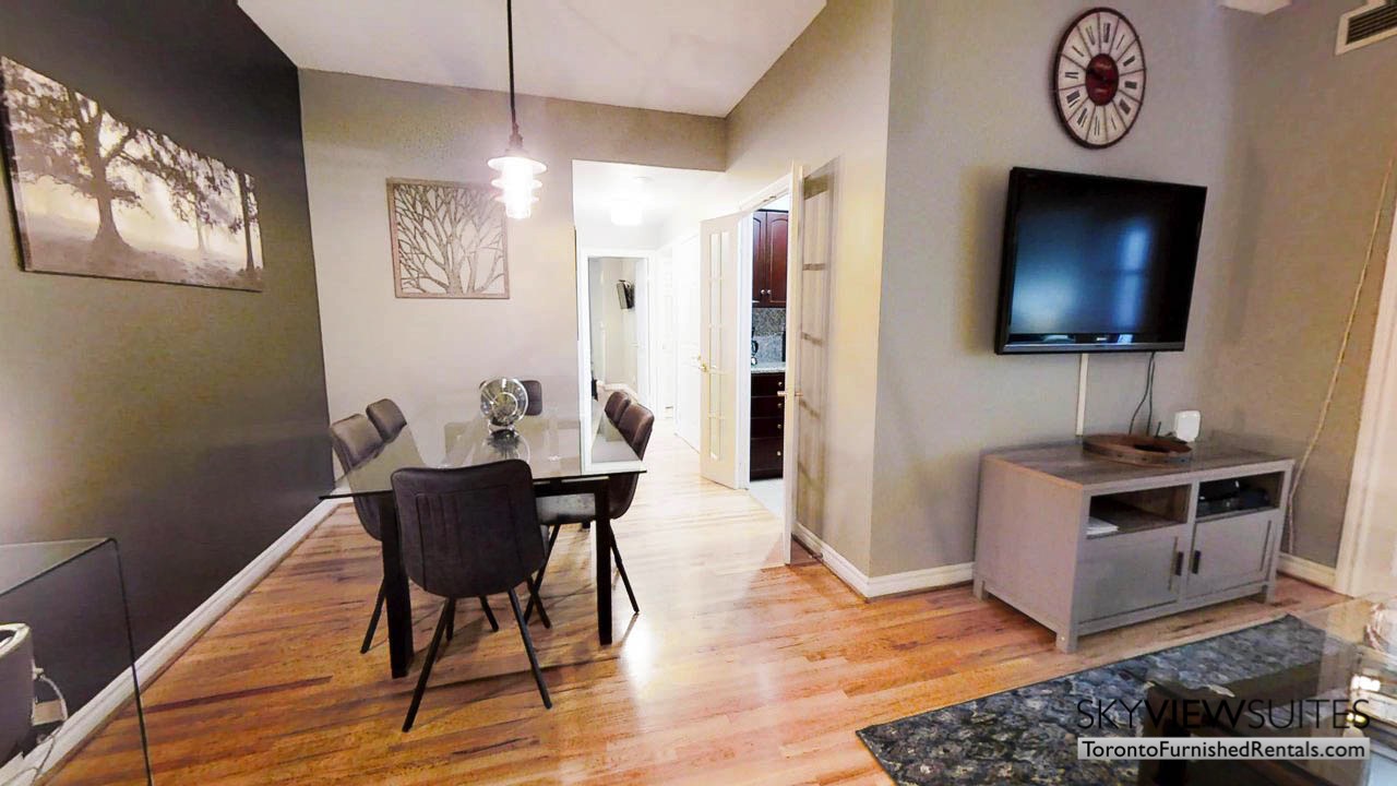 short term rentals toronto qwest living room with dining table and wall-mounted television