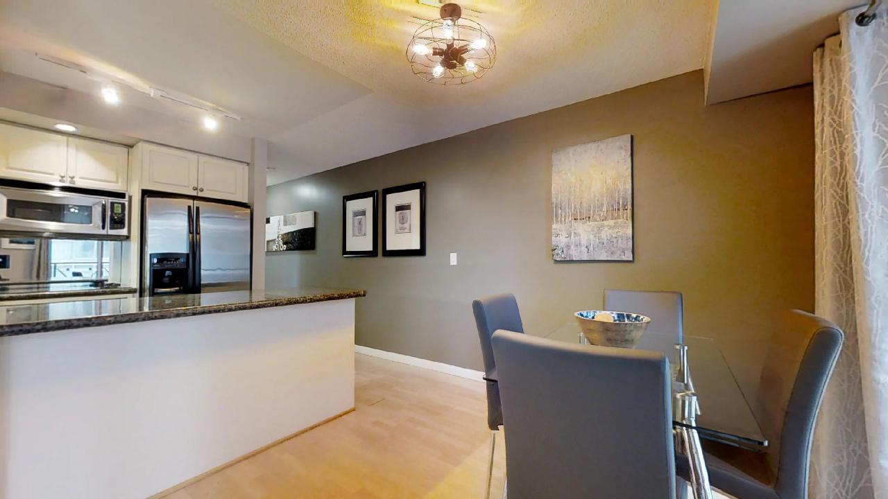 dining area and kitchen with art on the walls in a furnished apartment in downtown toronto