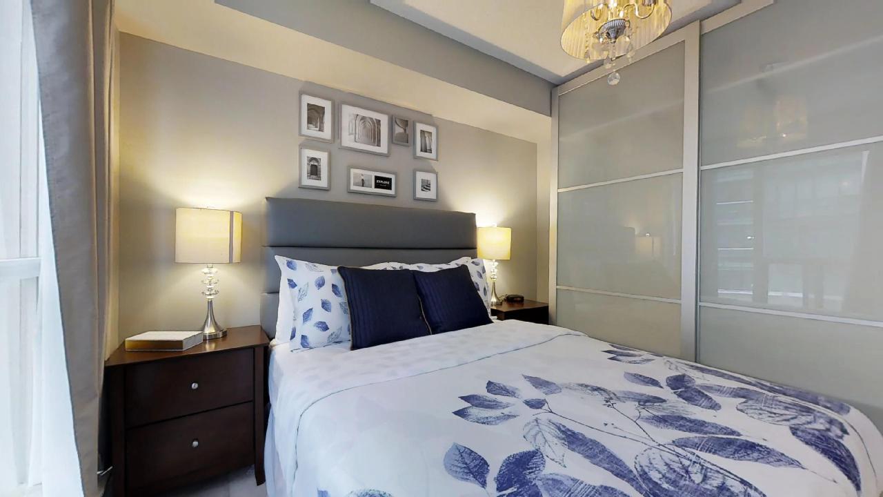 a blue bed with wall art in a toronto furnished apartment