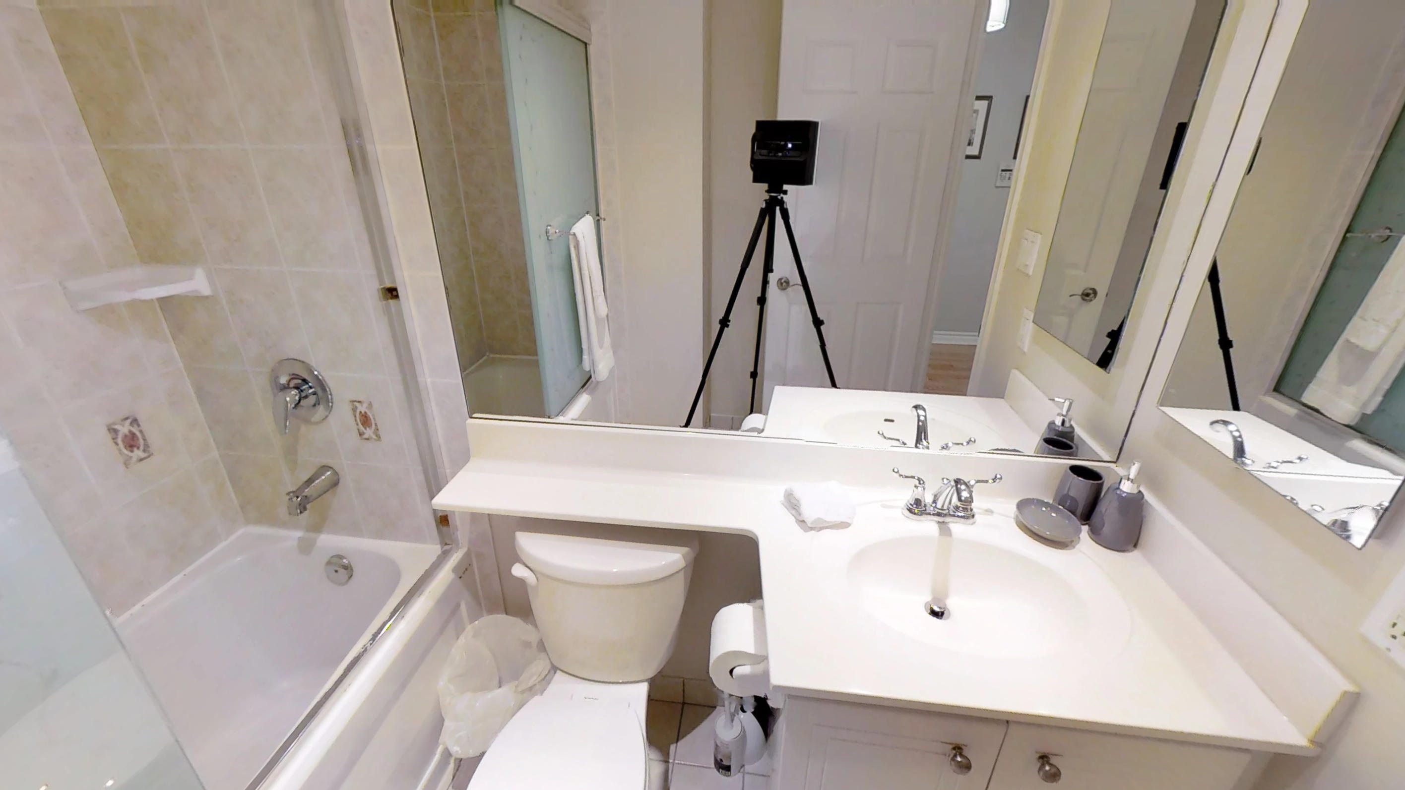 a view of the shower, countertop and toilet in the furnished bathroom of Icon G, near the CN tower in downtown Toronto.