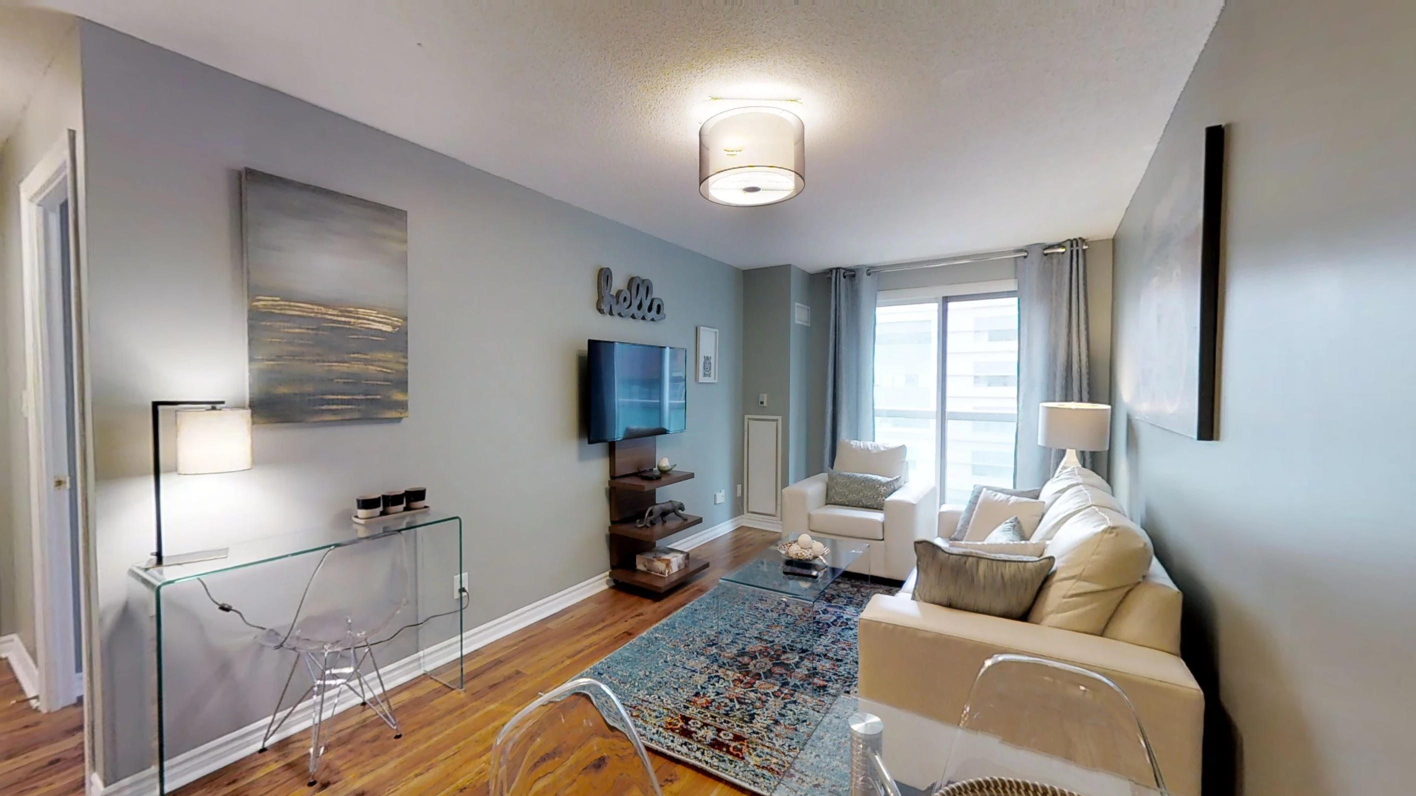 rugs, wall art, and window in the living room of a furnished apartment in Toronto's Financial District