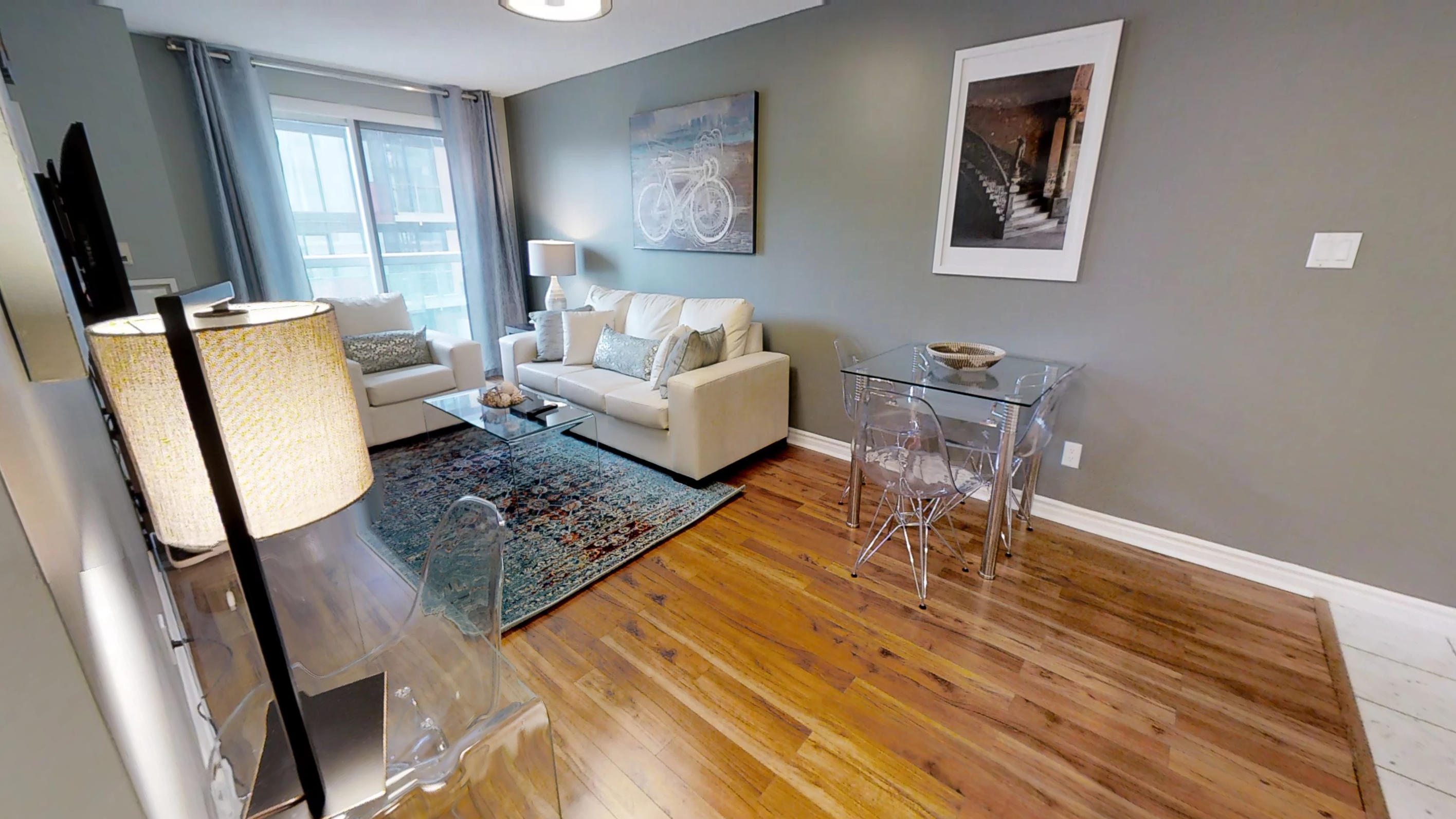 the main living space of a Sky View Suites toronto furnished apartment, located at Qwest condos on 168 simcoe street