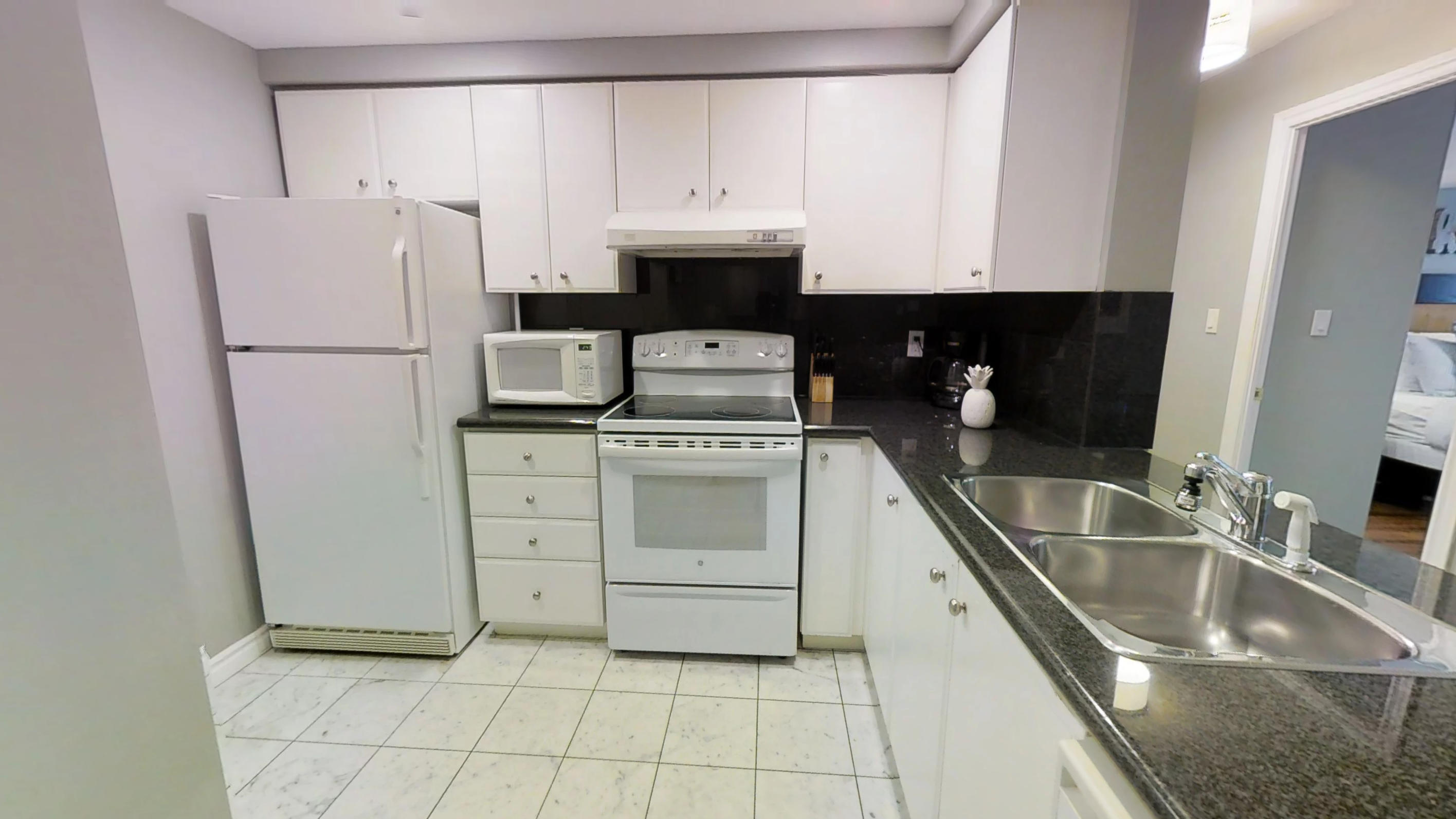 The fully furnished kitchen in a Qwest condominium, furnished by Sky View Suites in downtown Toronto.